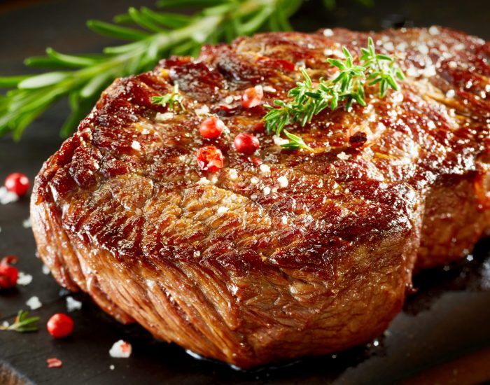 Roast beef served on wooden cutting board Close up of roast beef served with spices on wooden cutting board